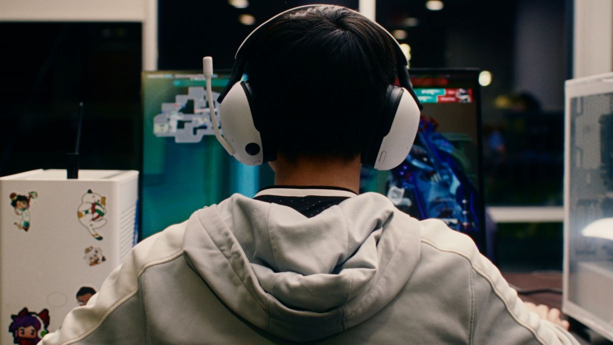 Bentley student wearing headset and gaming