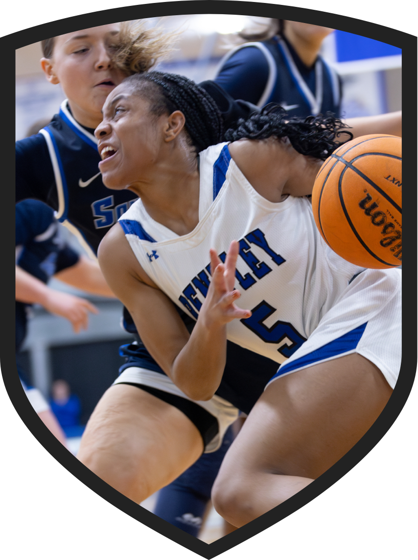 a Bentley student-athlete drives a baskball down the court