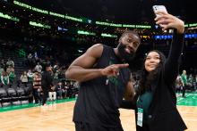 Celtics player Jaylen Brown poses with a high schooler on the TD Garden basketball court