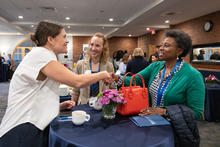 Three female summit participants network during the AI Summit.