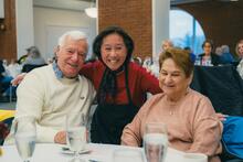 Three people smiling at a luncheon event