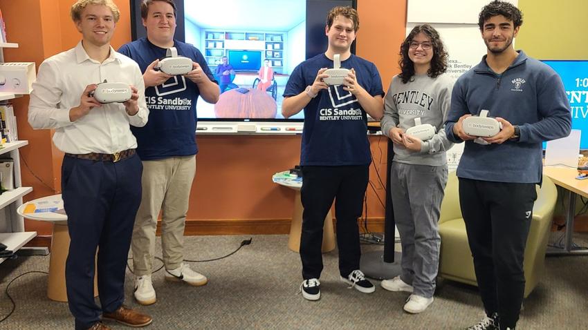 Six Bentley students hold virtual reality headsets. 