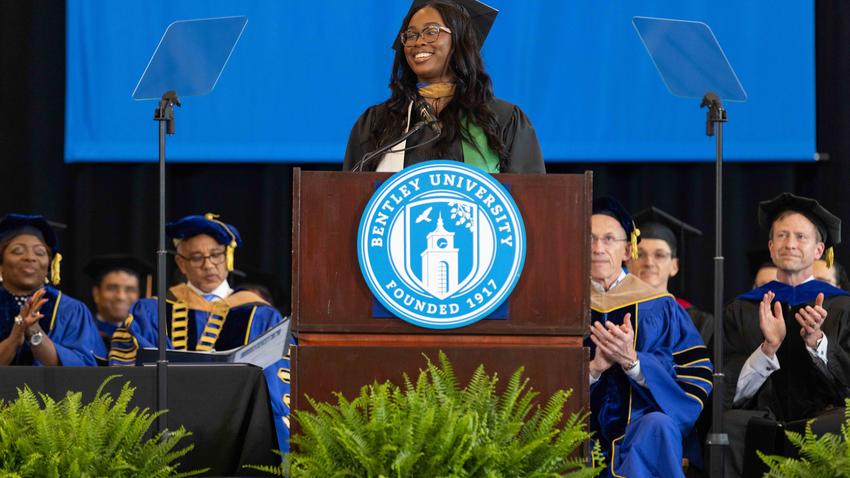 Aleshia Green '19 MSF '24 delivers her commencement address at the podium 