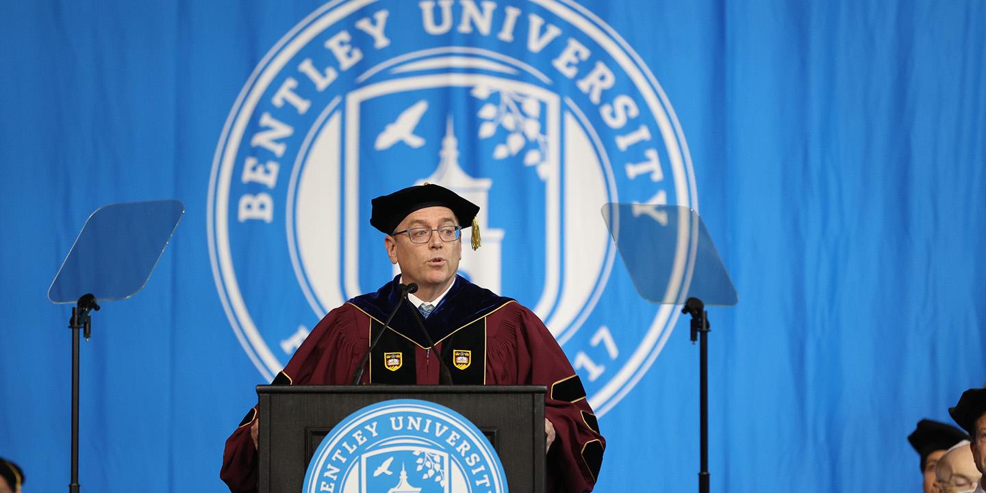 Andrew speaking at the podium in the arena